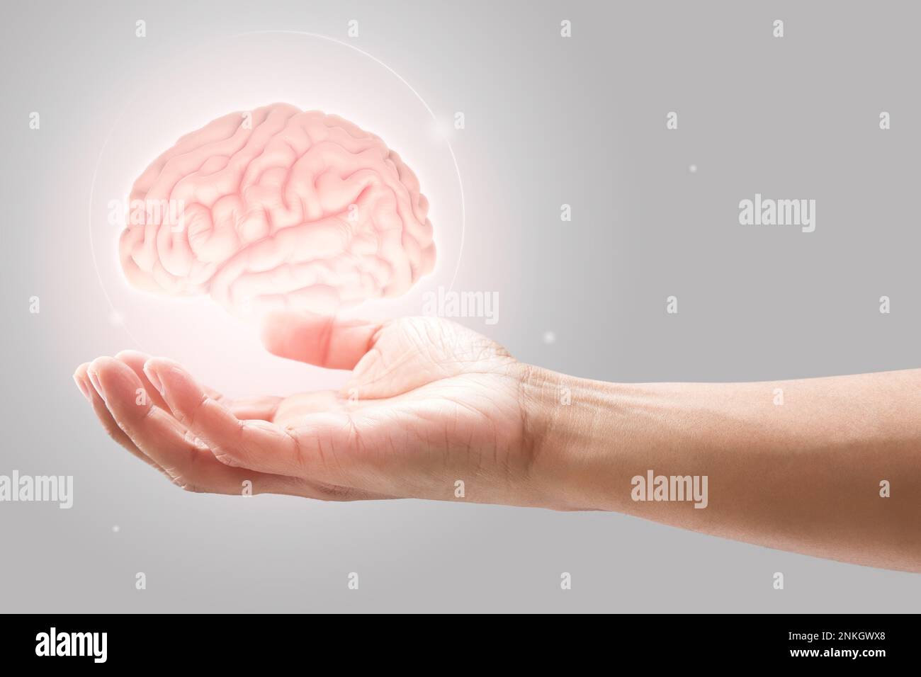 Mann hält Gehirn Abbildung gegen grauen Hintergrund. Konzept mit der psychischen Gesundheit Schutz und Pflege. Stockfoto