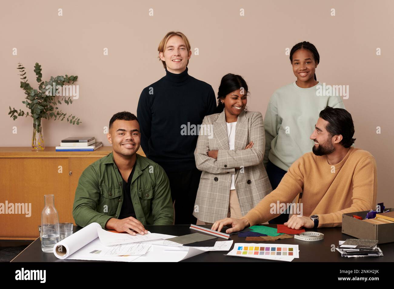 Fröhliche Modedesigner am Arbeitsplatz Stockfoto