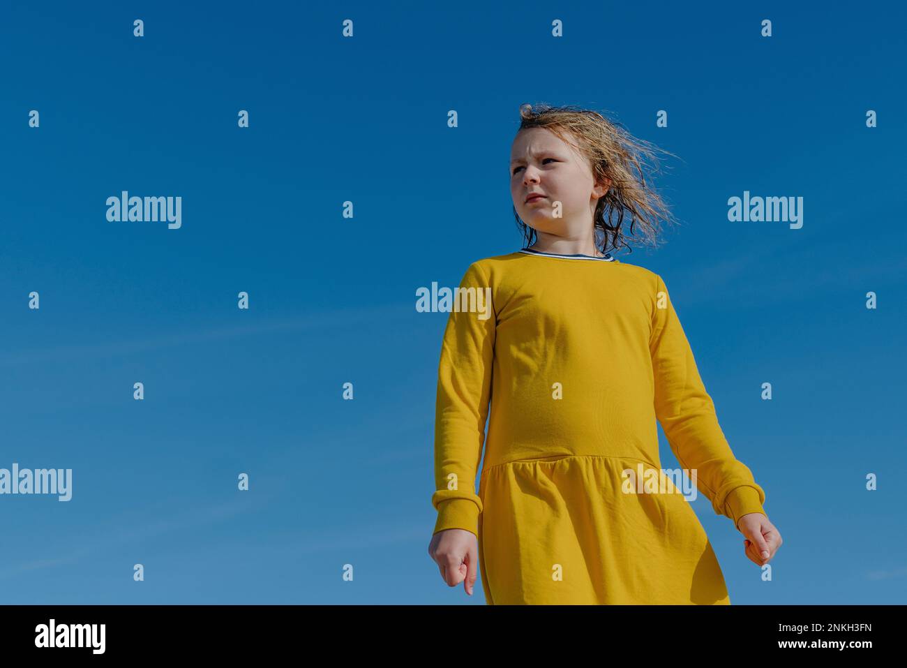 Rücksichtsvolles Mädchen, das unter blauem Himmel mit nassen Haaren steht Stockfoto