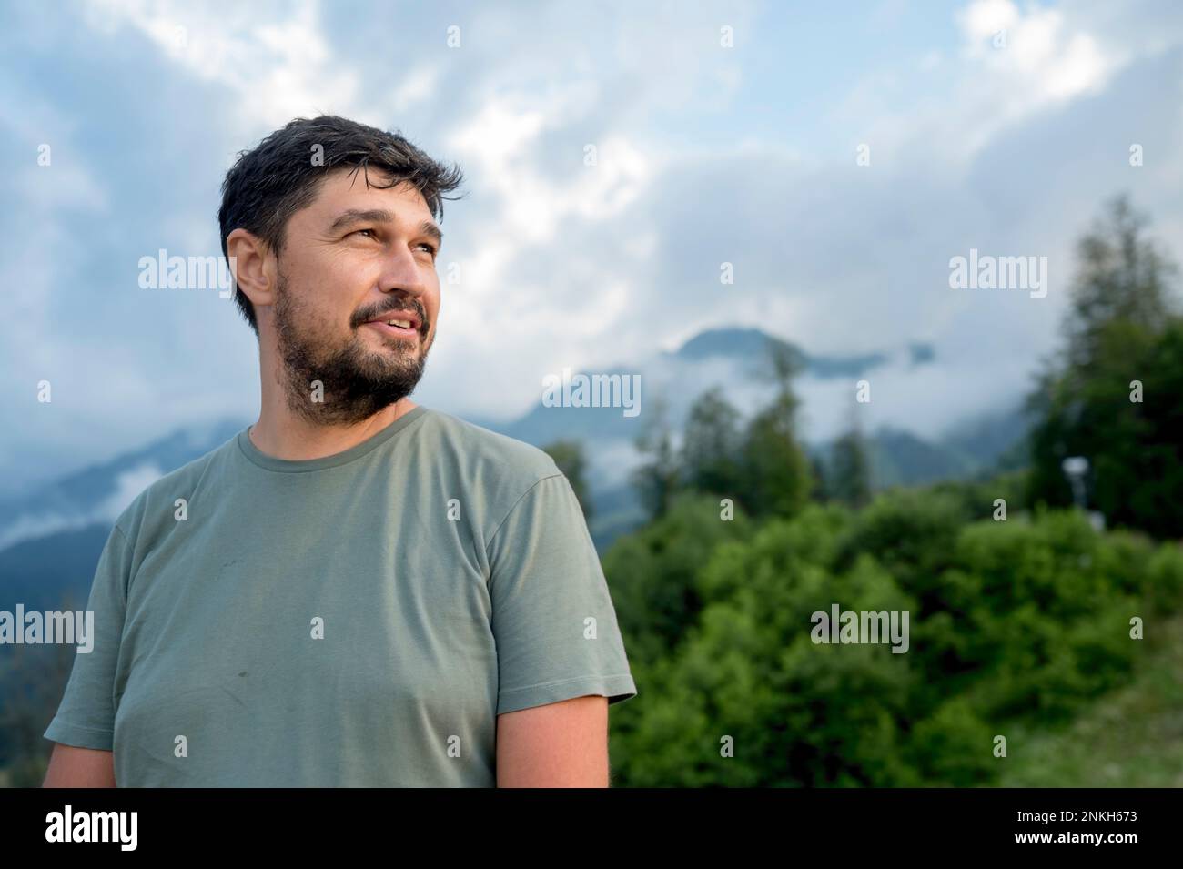 Lächelnder Mann mit Berg im Hintergrund im Urlaub Stockfoto