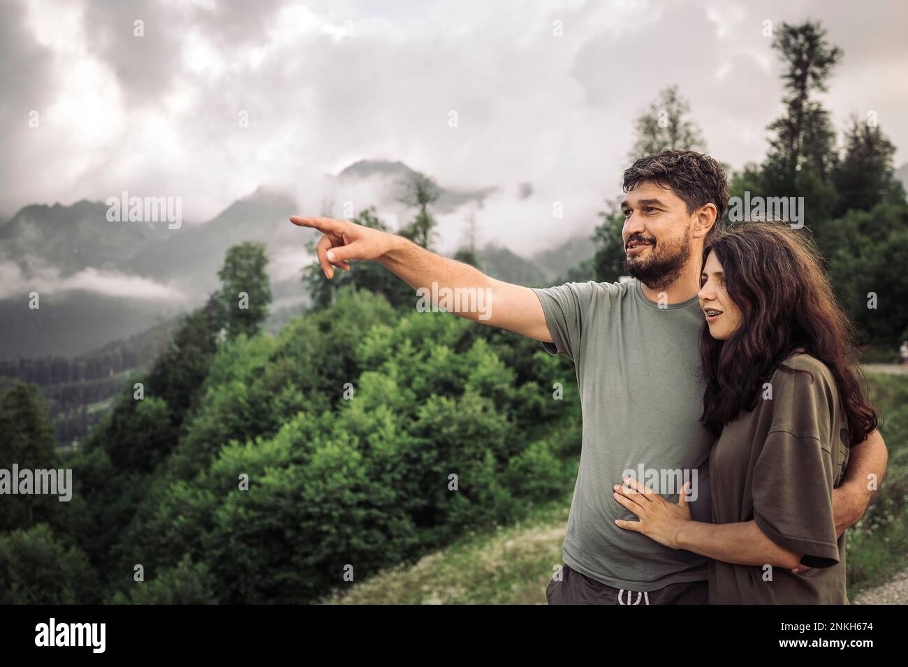 Ein lächelnder Mann, der im Urlaub von einer Frau gestikuliert wird Stockfoto