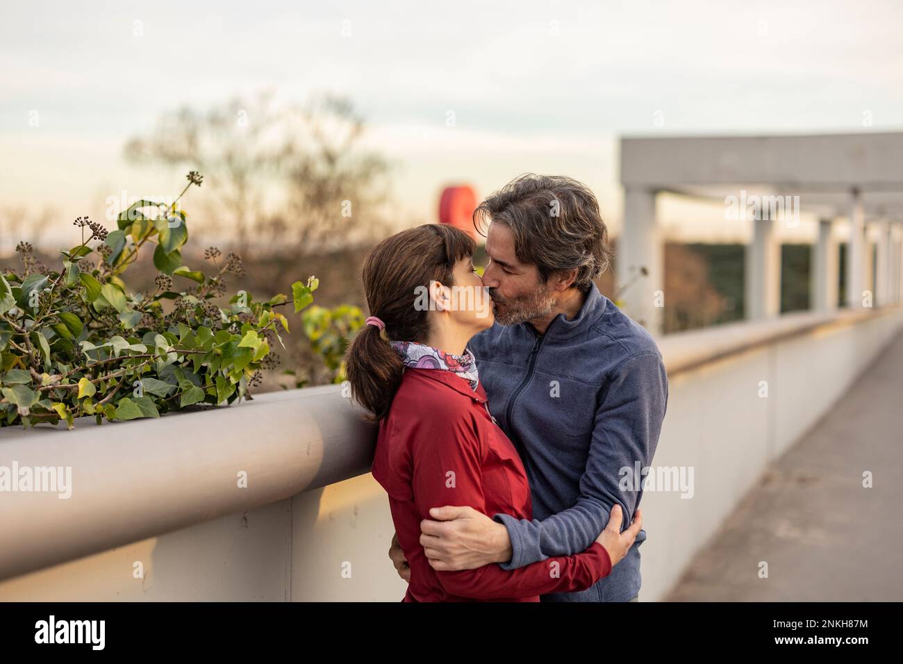 Reifes Paar, das sich am Geländer küsst Stockfoto
