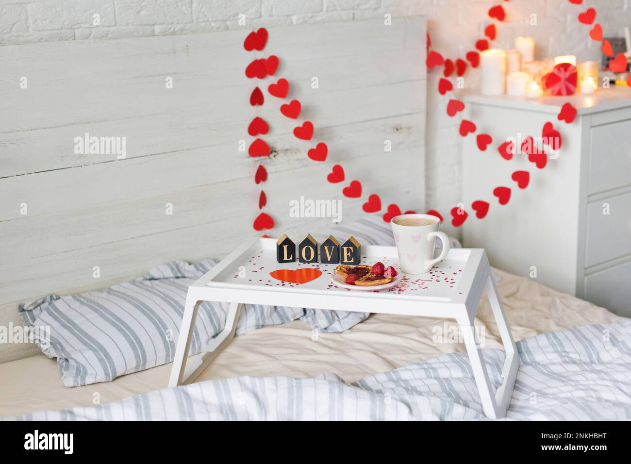 Frühstückstablett mit herzförmiger Dekoration im Schlafzimmer zu Hause Stockfoto