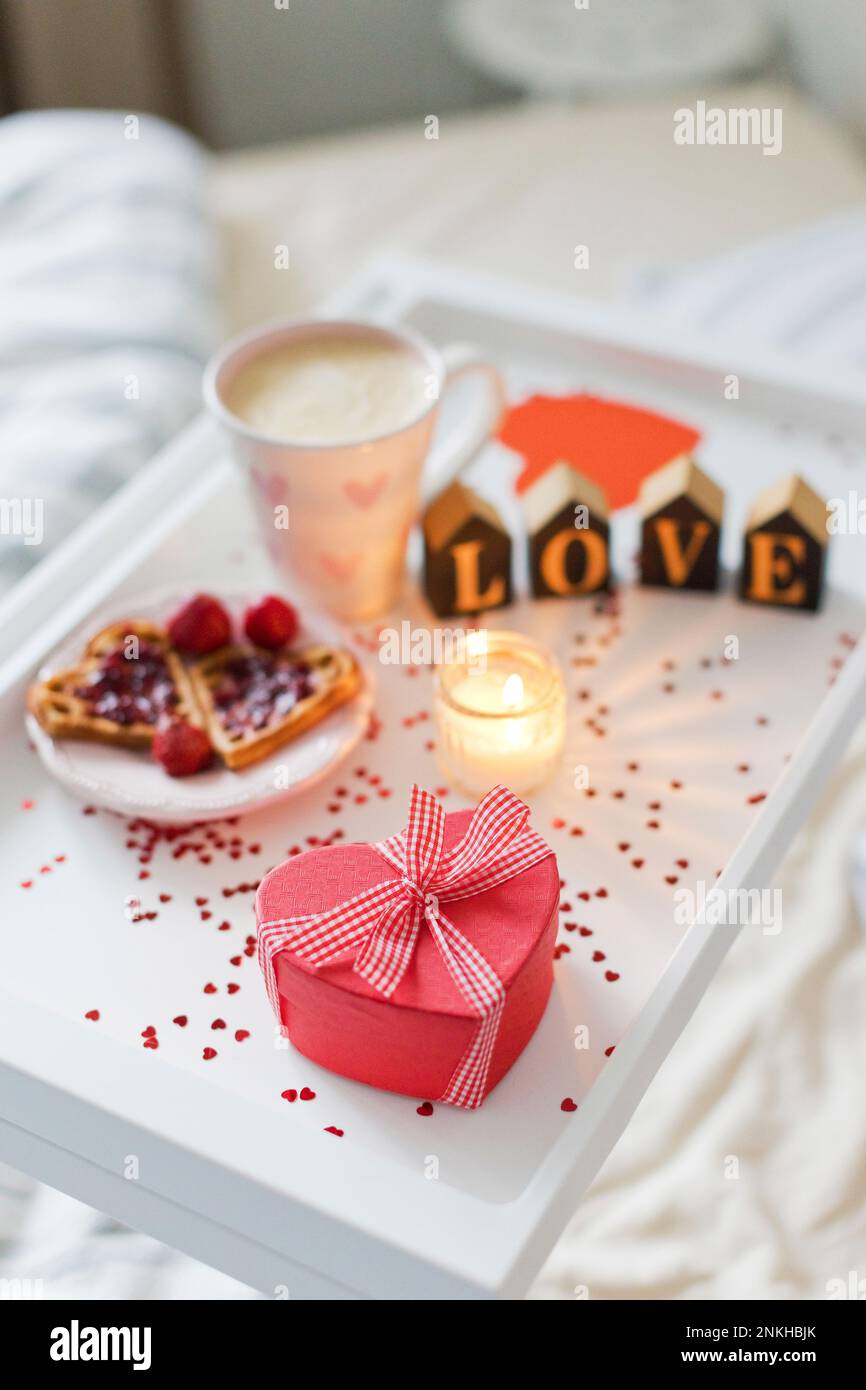 Herzförmige Geschenkbox mit Frühstück auf dem Tablett Stockfoto