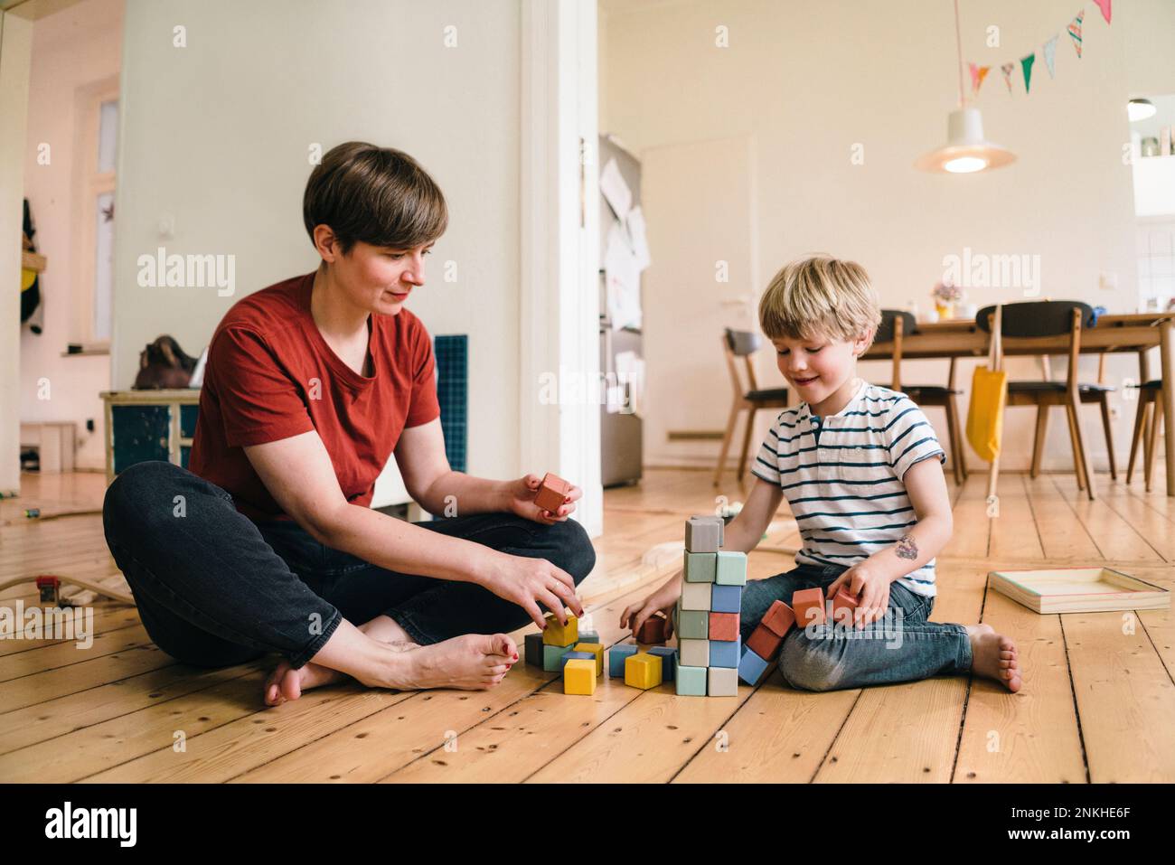 Mutter und Sohn spielen mit Spielzeugblöcken, die zu Hause sitzen Stockfoto