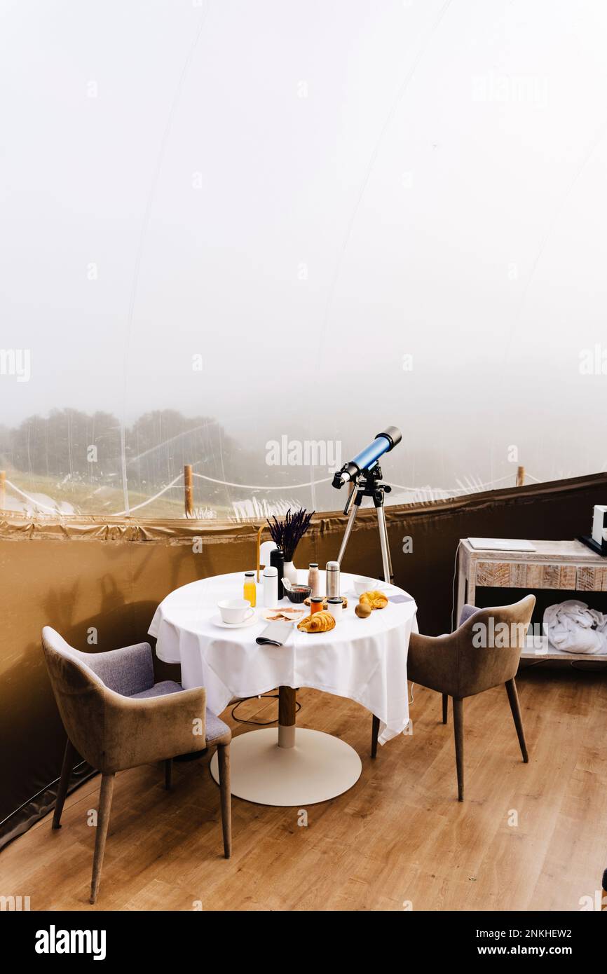 Esstisch und Teleskop im Kuppelzelt Stockfoto
