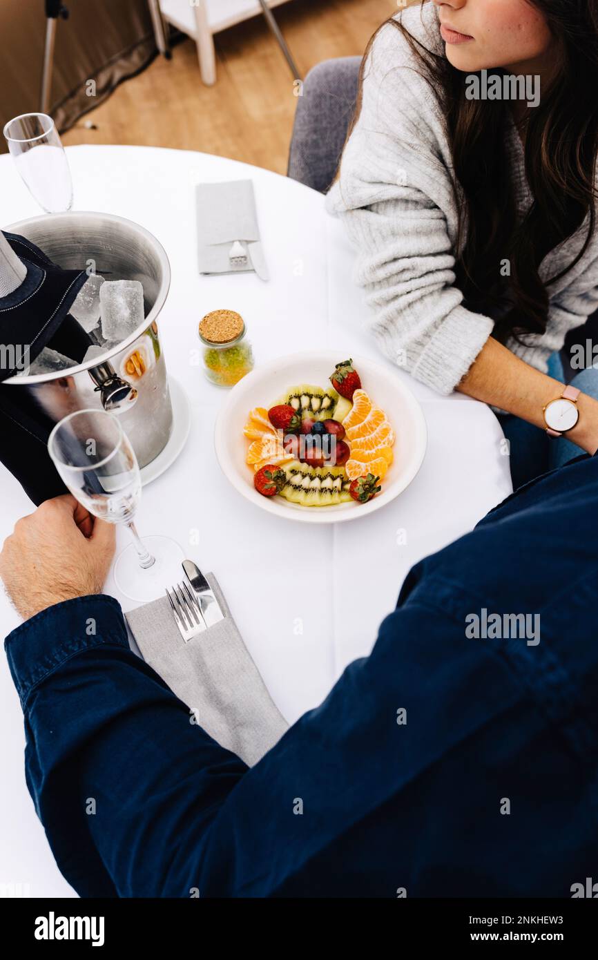 Ein Paar mit einer Schüssel mit frischem Obst, die am Esstisch im Kuppelzelt sitzt Stockfoto