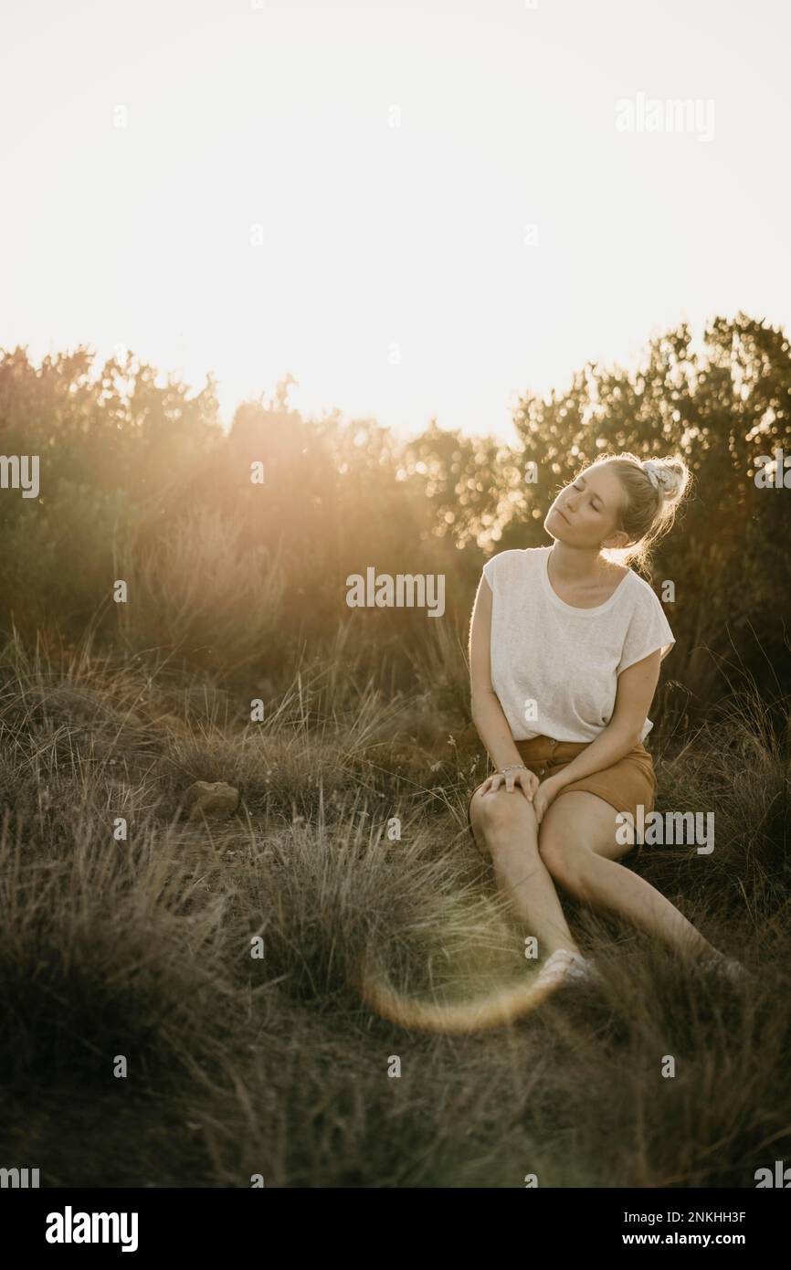 Frau genießt Sonnenlicht im Park Stockfoto