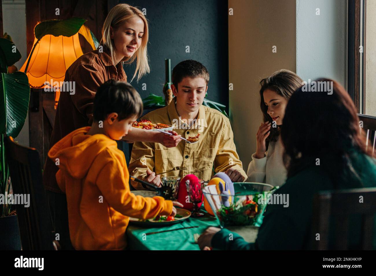 Glückliche Familie mit Osteressen an einem Tisch zu Hause Stockfoto