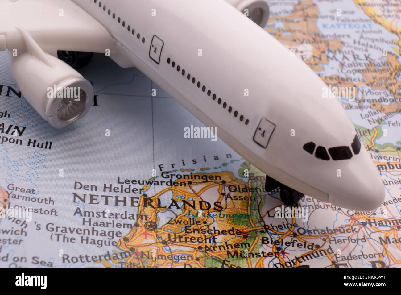 Nahaufnahme eines Miniatur-Passagierflugzeugs auf einer farbenfrohen Karte, die Amsterdam, Niederlande, durch selektiven Fokus, Hintergrundunschärfe zeigt Stockfoto