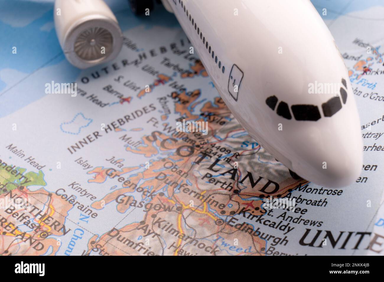 Nahaufnahme eines Miniatur-Passagierflugzeugs auf einer farbenfrohen Karte, die Edinburgh, Dundee Schottland durch selektiven Fokus und Hintergrundunschärfe zeigt Stockfoto