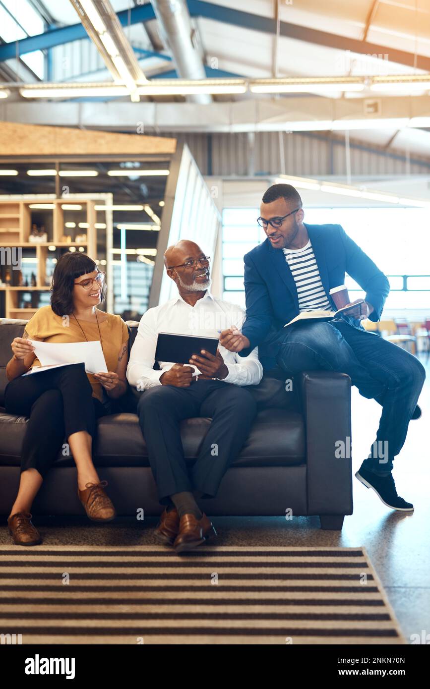 Es ist immer toll, wenn alle auf der gleichen Seite sind. Gesamtbild einer Gruppe von Designern, die in einem Büro diskutieren. Stockfoto