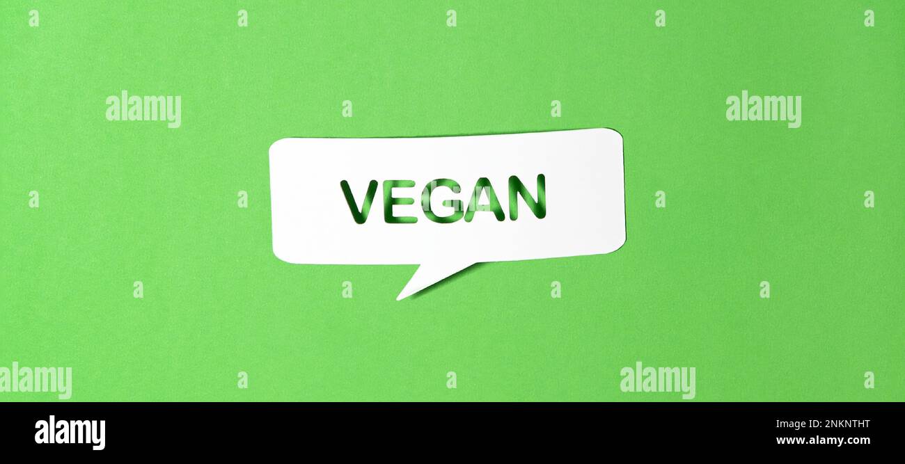 Englischer Text vegan in Papier Sprechblase auf Grünbuchhintergrund gestanzt. Fotorealistischer Vektor im Bannerformat. Stock Vektor