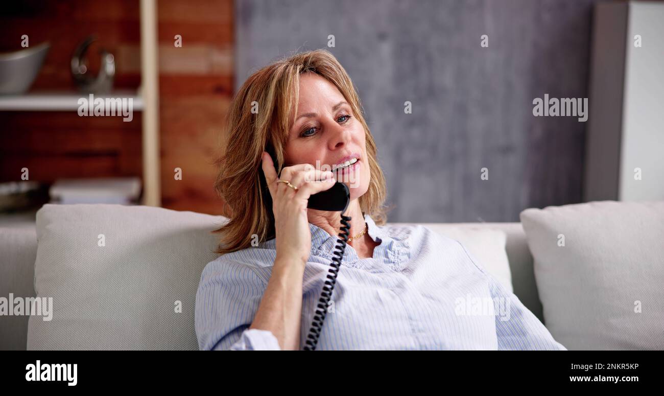 Seniorin Alte, Die Am Festnetztelefon Spricht Stockfoto
