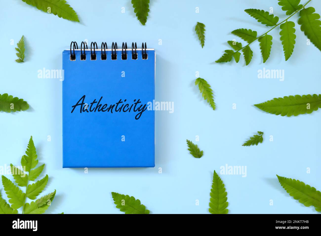 Authentizität und Persönlichkeitsbegriff. Ein Wort auf blauem Notizblock. Schöne minimalistische flache Lagezusammensetzung. Stockfoto