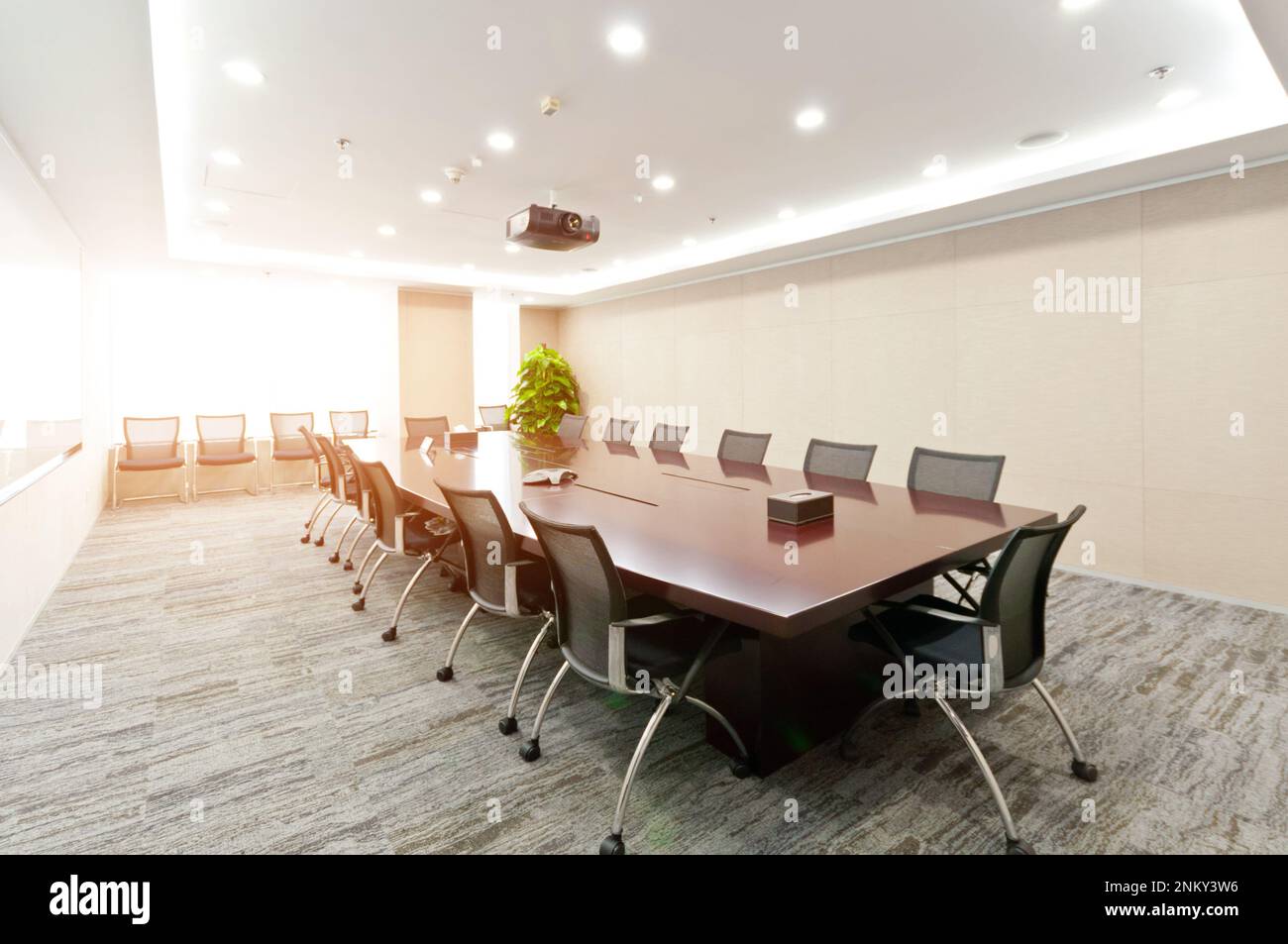 Ein moderner und geräumiger Konferenzraum mit zwei langen Tischen und Stühlen, perfekt für Geschäftstreffen, Seminare und andere Veranstaltungen Stockfoto