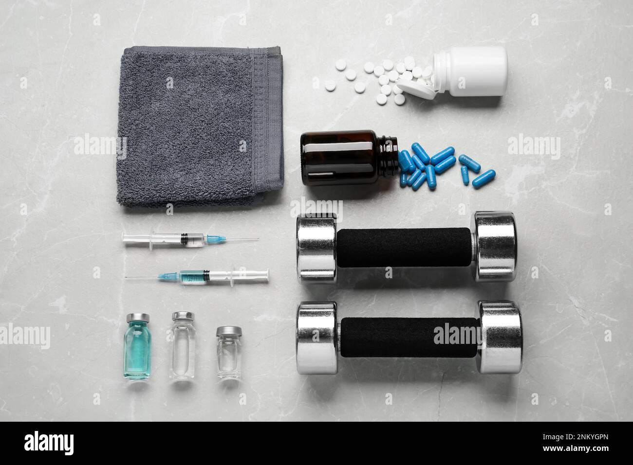 Verschiedene Drogen und Sportgeräte auf grauem Hintergrund, flach liegend. Dopingkontrolle Stockfoto