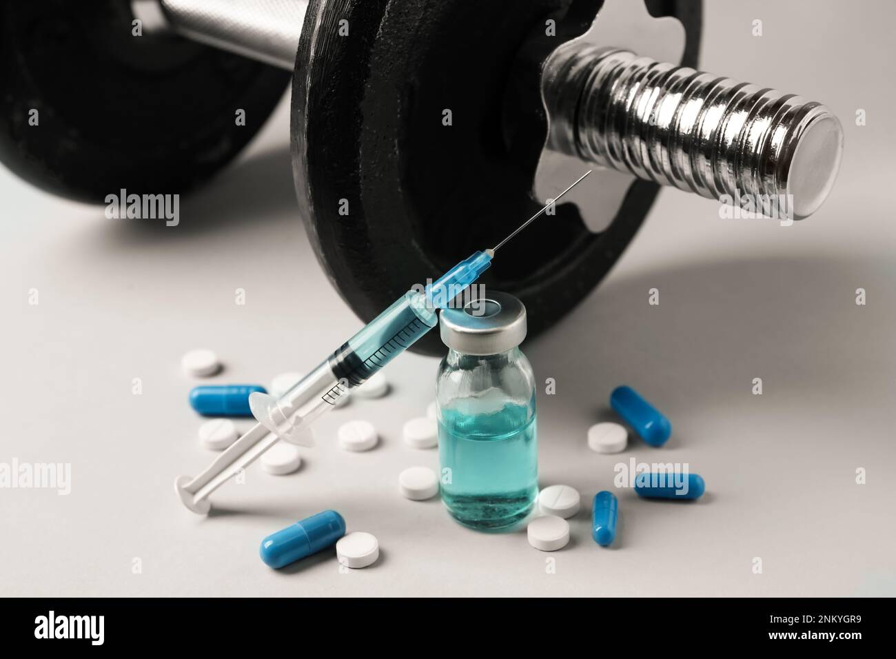 Verschiedene Drogen und Sportgeräte auf grauem Hintergrund. Dopingkontrolle Stockfoto