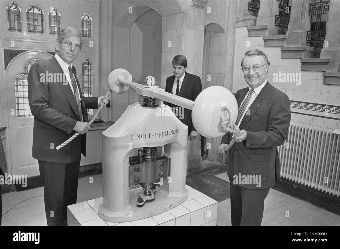 Staatssekretär King schlägt ersten Golddukat 1985; Staatssekretär Koning (r) und Münzmeister De Jong (l) bei der Münzpresse ca. 1985 Stockfoto