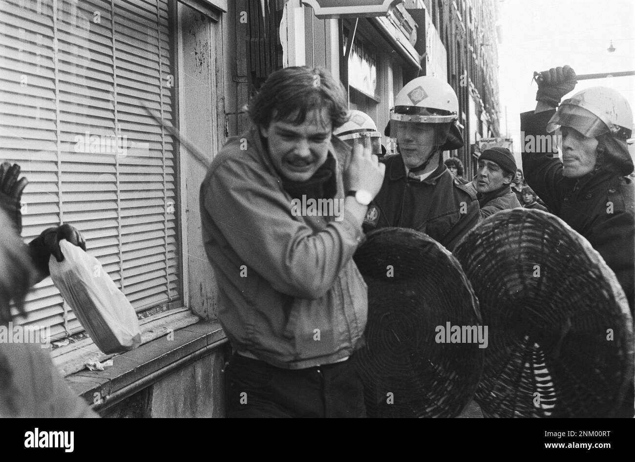 Niederländische Geschichte: Polizei und Armee mit gepanzerten Fahrzeugen und Panzern räumen Barrikaden in Vondelbuurt, Amsterdam; Mobile Einheit trifft einen Demonstranten ca. 3. März 1980 Stockfoto