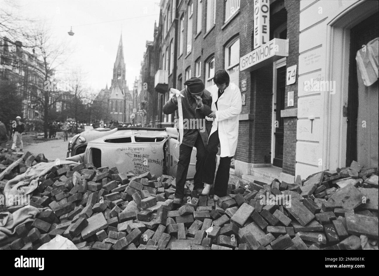 Niederländische Geschichte: Polizei und Armee mit gepanzerten Fahrzeugen und Panzern räumen Barrikaden in Vondelbuurt, Amsterdam; eine verletzte Person wird weggebracht (besetzte Aufstände) ca. 3. März 1980 Stockfoto
