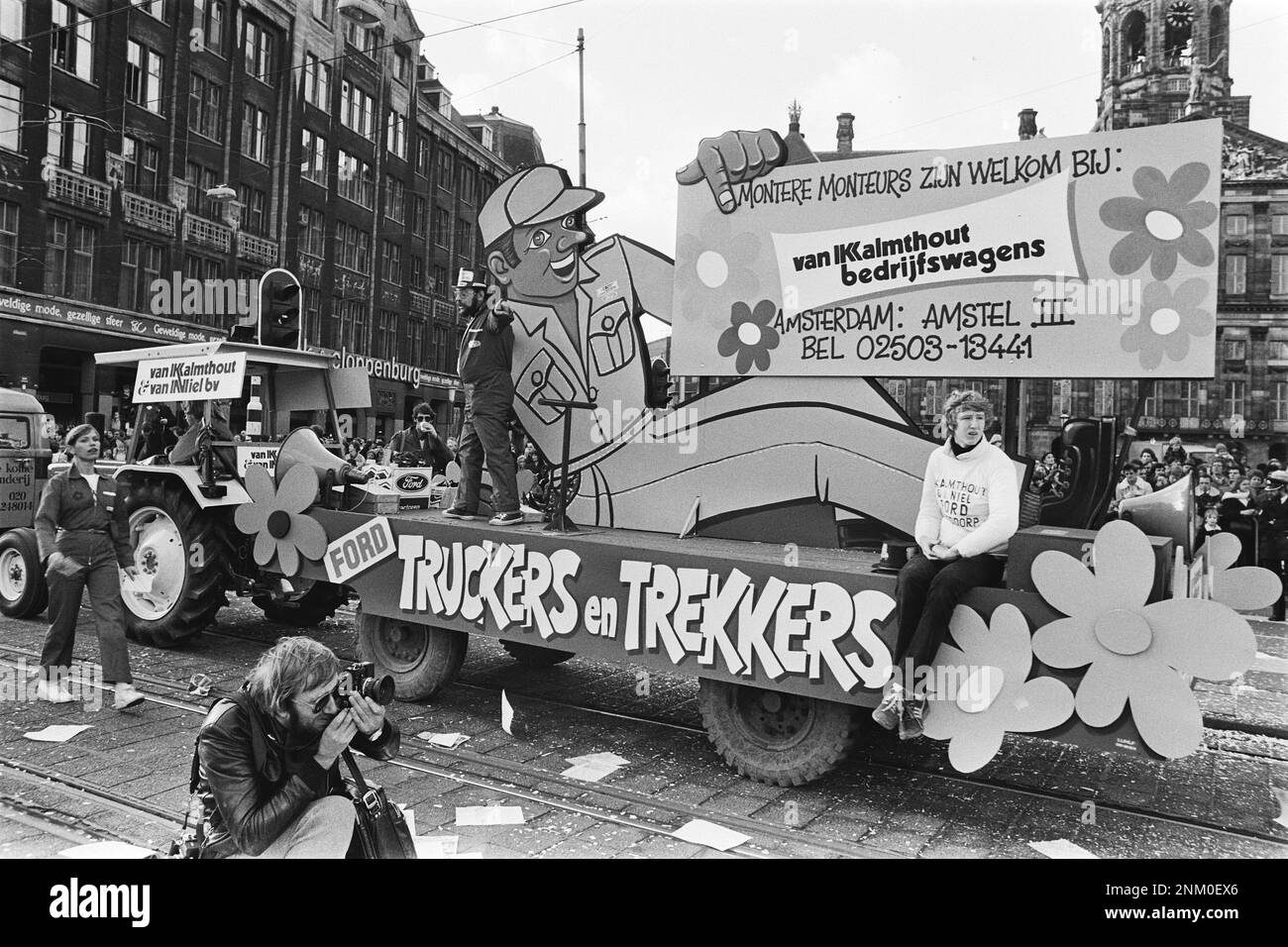 Niederländische Geschichte: Karneval in Amsterdam, kommission Firma Kalmhout und van Niel (Auto mit liegendem Automechaniker) Schwimmer, Fotograf im Vordergrund ca. 10. Februar 1980 Stockfoto