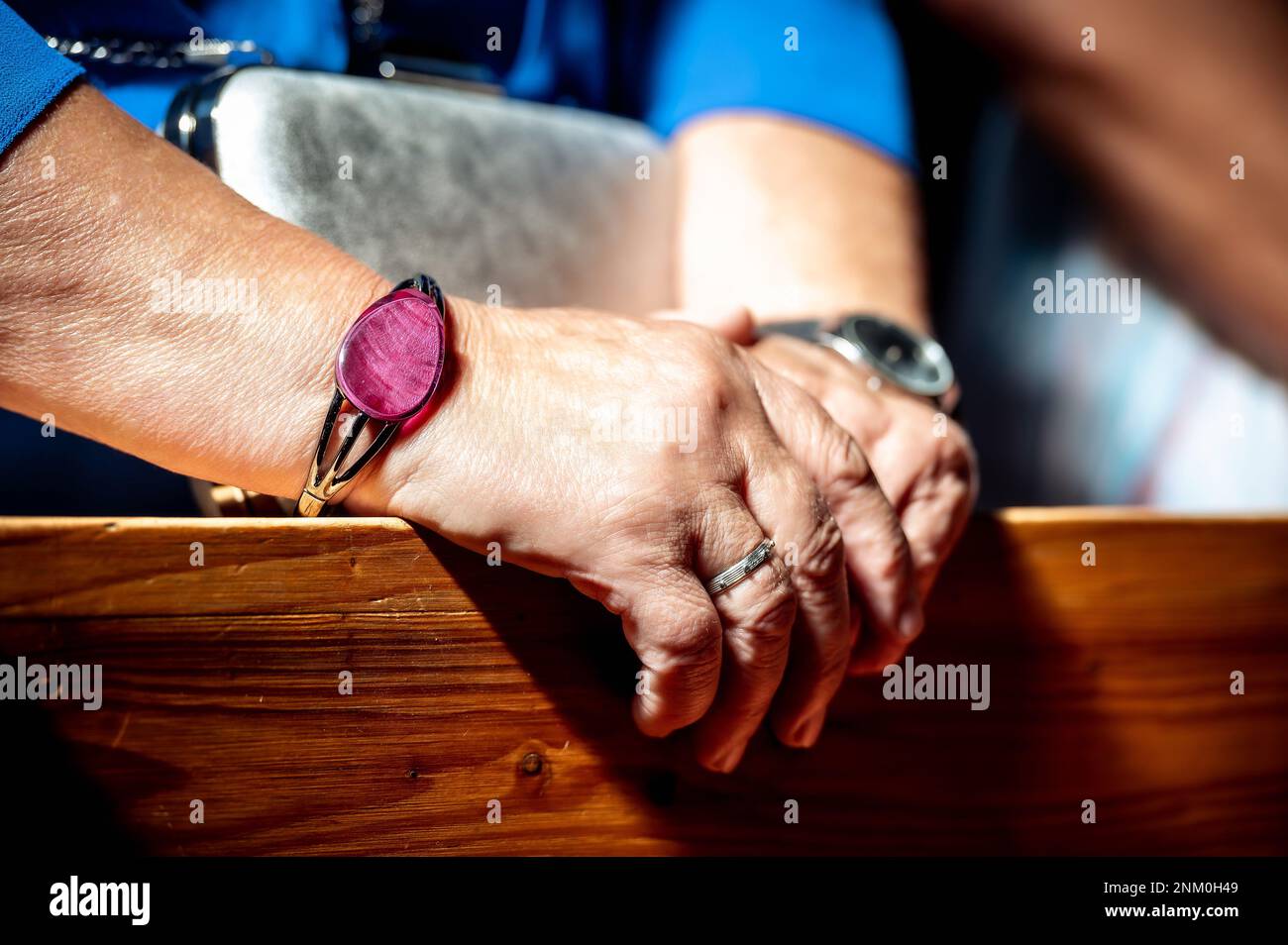 Hände, Eheringe und Ehegelübde die Hände der Großmutter während des Gebets in der Kirche Stockfoto