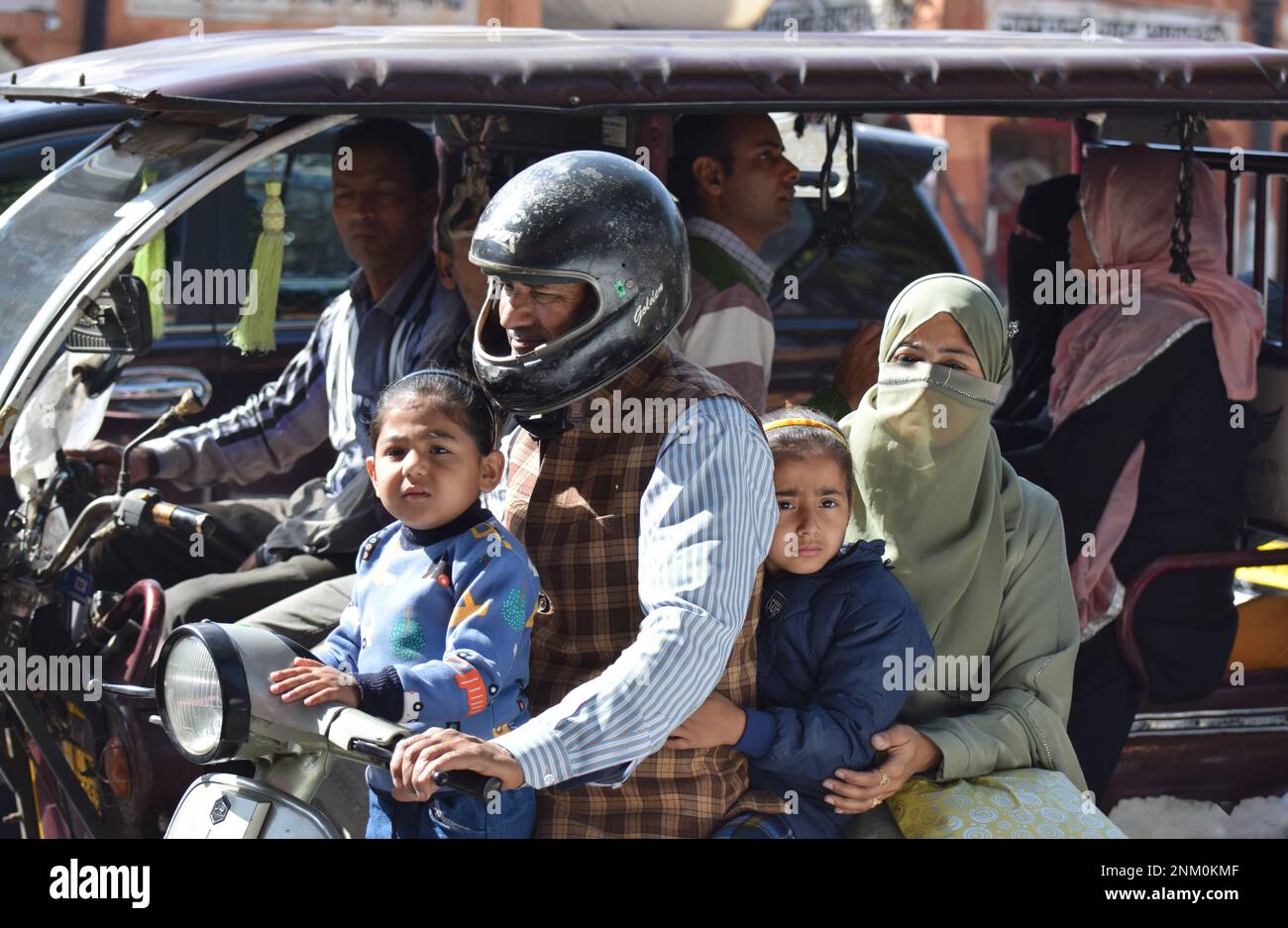 Eine 4-köpfige Familie, bestehend aus Mutter, Vater und 2 jungen Töchtern im Alter von etwa 3 und 6 Jahren, die alle zusammen mit dem fahrenden Vater auf einem Motorrad fahren Stockfoto