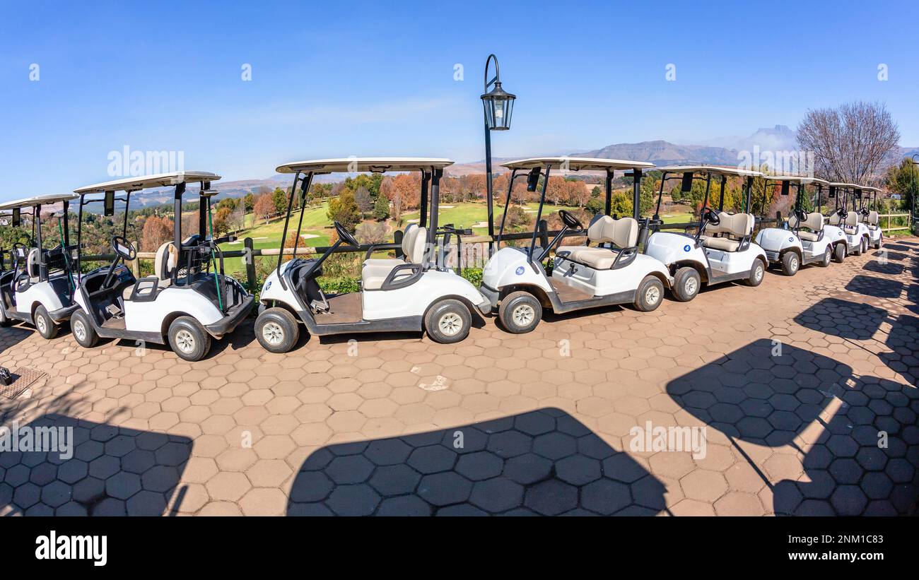 Golfplatzwagen parken in den Drakensberg-Bergen mit Blick auf die landschaftlich reizvolle Sportlandschaft. Stockfoto