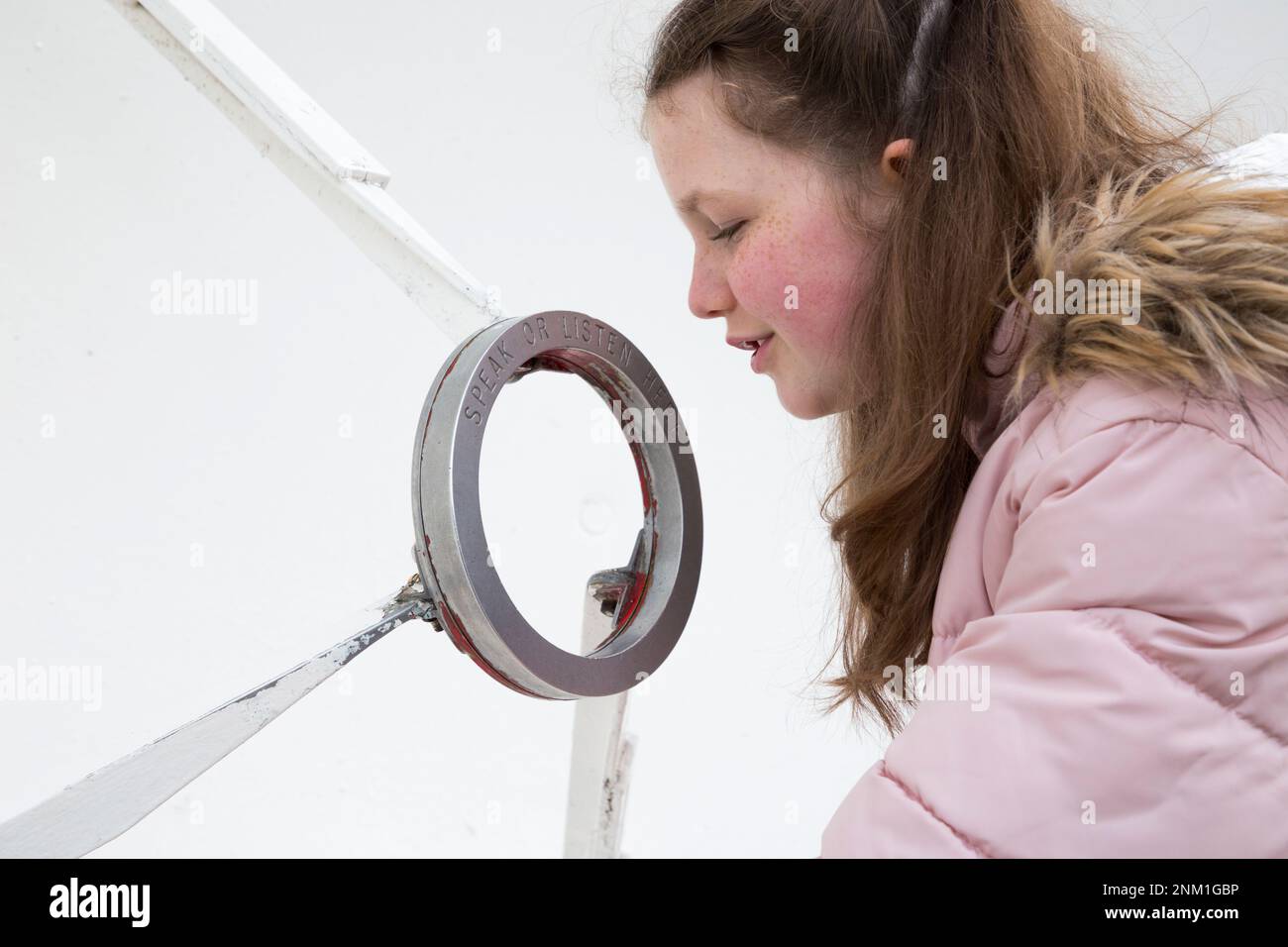 Kinder/Mädchen/Kinder/Kinder hören und sprechen auf der Flüsterschüssel/dem Geschirr, das als akustischer Spiegel dient, um Schallwellen zu übertragen und zu fokussieren. (133) Stockfoto