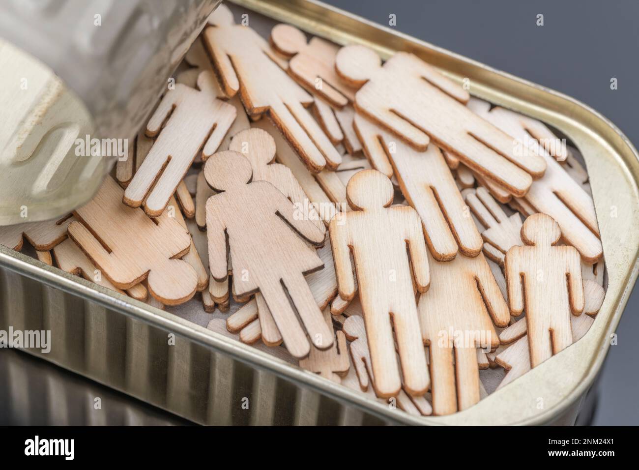 Lasergeschnittenes Holz, männlich und weiblich, verpackt in einer Metallsardinendose. Für Leute, die wie Sardinen gepackt, zusammengequetscht, nicht genug Platz, um sich zu bewegen. Stockfoto