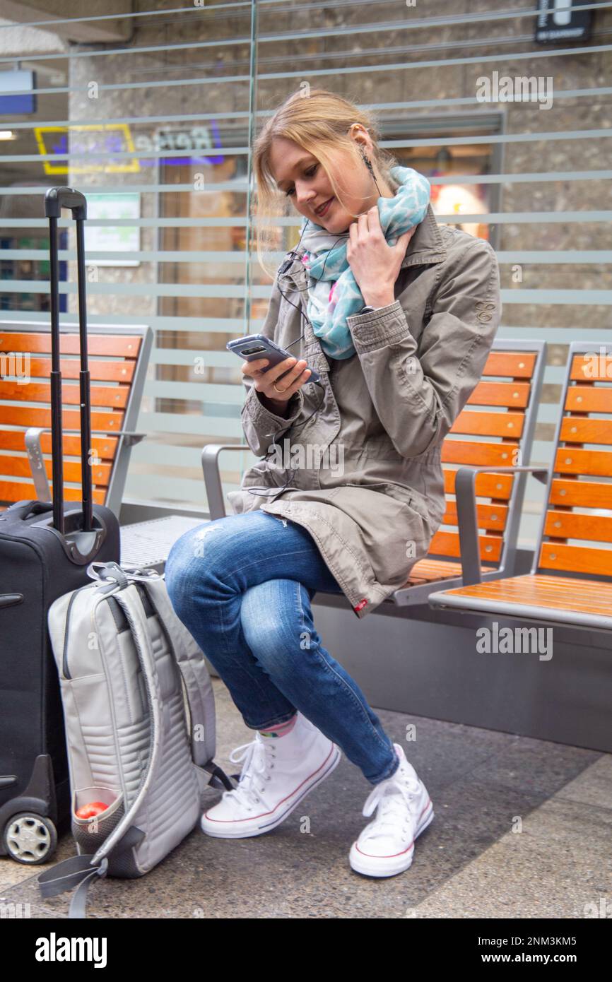 Junge Frau im Bahnhof wartet auf einen Zug (Modell freigegeben) Stockfoto