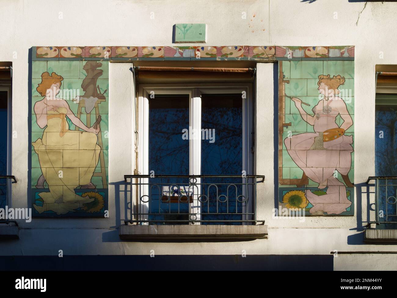 Zwei Art-Noveau-Fliesen-Tafeln von zwei weiblichen Künstlern, die ein Fenster und einen Balkon flankieren, Paris, Frankreich Stockfoto