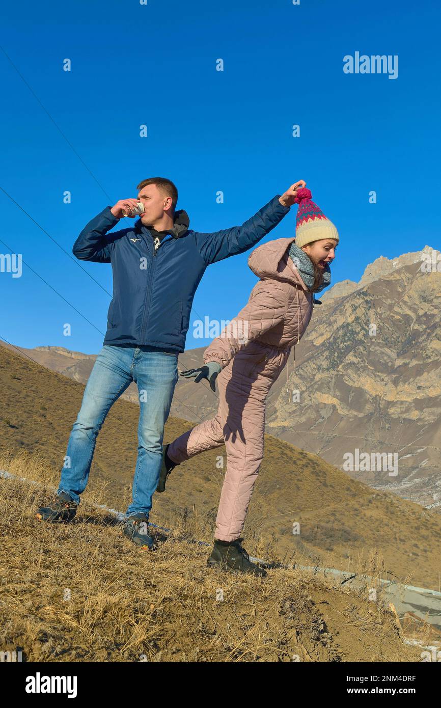 Fröhliche Paare spielen im Winter in den Bergen Stockfoto