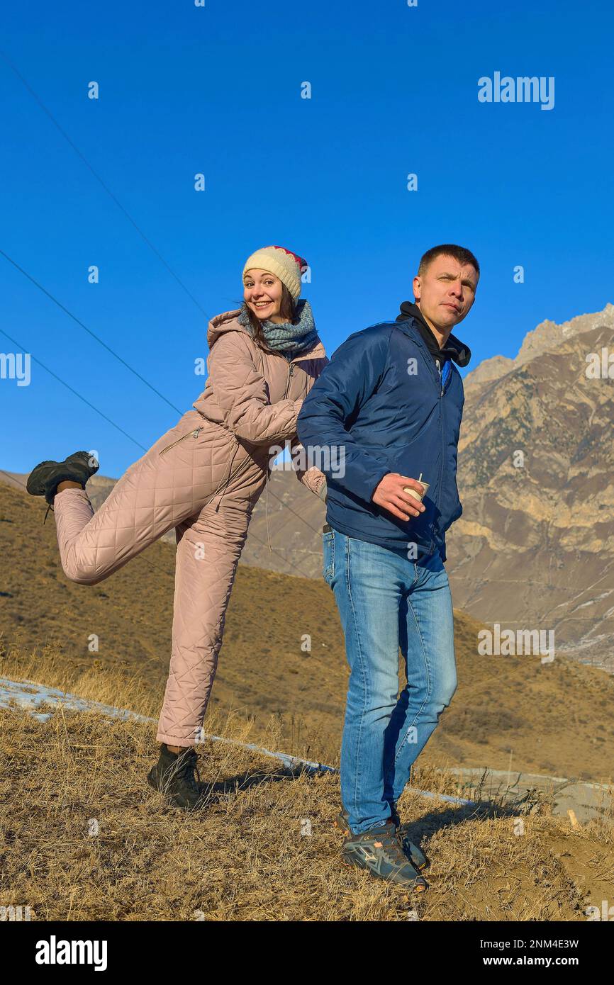 Fröhliche Paare spielen im Winter in den Bergen Stockfoto