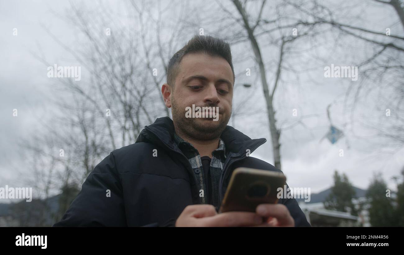 Attraktiver junger Mann mit feiner Haut, kurzen Haaren und Smartphone ärgert sich, wenn er im Freien Textnachrichten schreibt oder Online-Zahlungen tätigt Stockfoto Attraktiver junger Mann mit feiner Haut, kurzen Haaren und Smartphone ärgert sich, wenn er im Freien Textnachrichten schreibt oder Online-Zahlungen tätigt Stockfoto