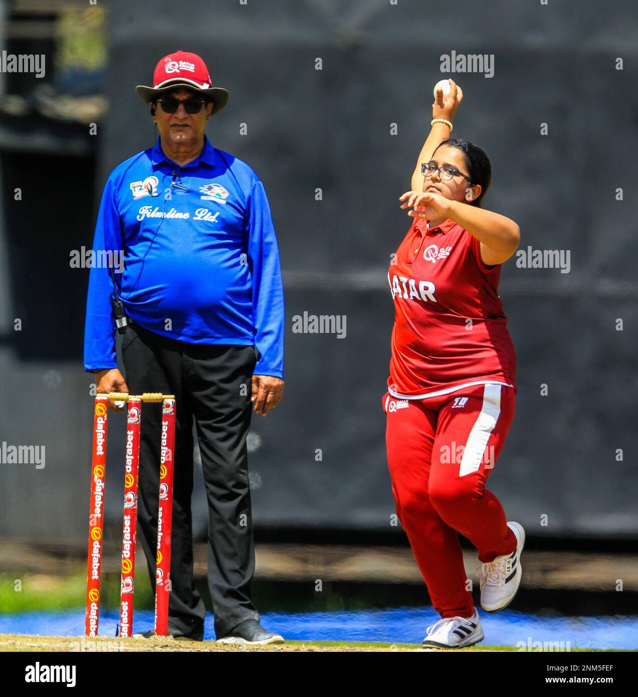 NAIROBI, KENIA - DEZEMBER 19: Katar-Bowler Aleena Khan bowlt gegen Uganda, überwacht von Schiedsrichter Asgar Ali während des Afrika-Frauen-Vierecks T20 bis Stockfoto