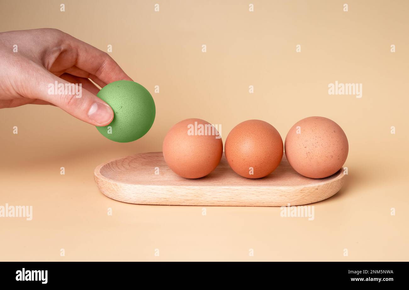 Handnahme in grünem Ei gefärbt zu Ostern, Auswahl aus ungesäuerten Hühnereiern in der Schale aus dem Holztablett. Hochwertiges Foto Stockfoto
