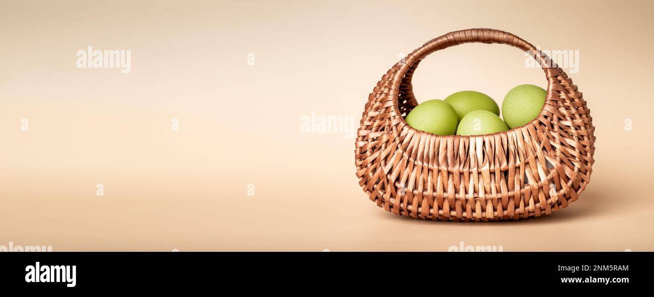Grüne, natürlich gefärbte Ostereier in Korb aus Korb. Werbebanner, Hintergrund mit Textbereich, Werbeaktion. Hochwertiges Foto Stockfoto