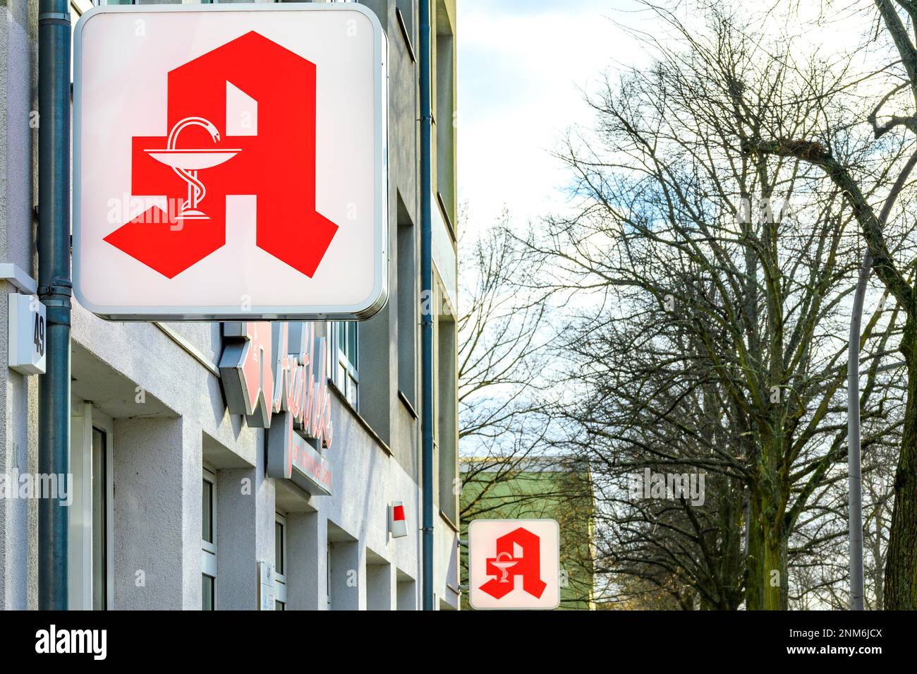 Berlin, Deutschland - 28. Januar 2022: Blick entlang einer Fassade mit dem Zeichen einer Apotheke im Vordergrund. Stockfoto