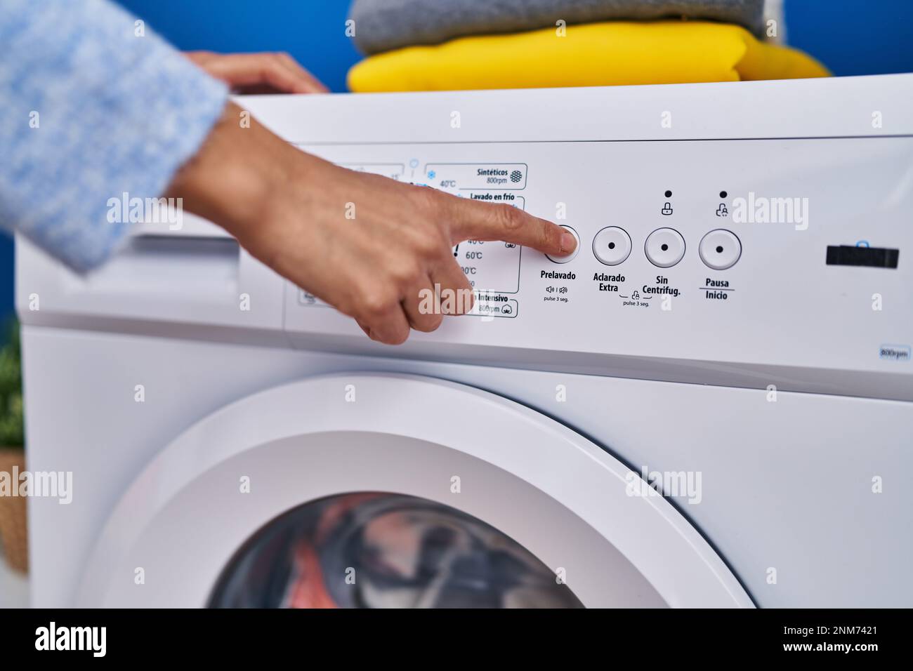 Junge Frau, die die Waschmaschine in der Waschküche anmacht Stockfotografie  - Alamy