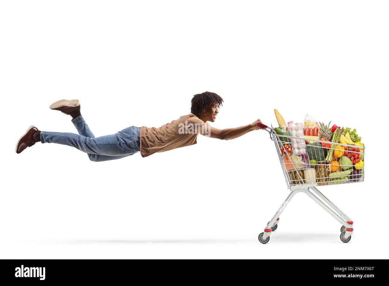 Ein afroamerikanischer Typ fliegt und hält einen vollen Einkaufswagen isoliert auf weißem Hintergrund Stockfoto