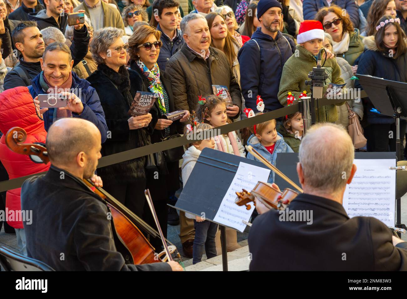 Granada, Spanien; 18. Dezember 2022: Einige Musiker und der Dirigent des Granada Symphony Orchestra spielen ein Weihnachtslied auf der Straße Stockfoto