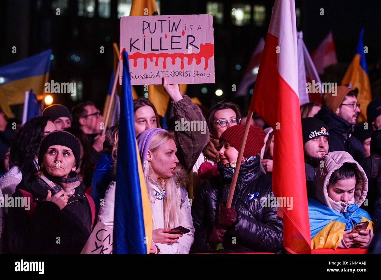 Danzig, Polen. 24. Februar 2023. Menschen mit ukrainischer und polnischer Flagge, die am ersten Jahrestag des russischen Angriffs auf die Ukraine im Plac Solidarnosci an der Anti-Kriegskonferenz teilnehmen, werden am 24. Februar 2023 in Danzig (Polen) gesehen, wie ukrainische Mädchen ein Banner in der Hand halten, auf dem Putin ein Killer spricht. Russland ist ein terroristischer Staat sind gesehen (Foto von Michal Fludra/NurPhoto) Kredit: NurPhoto SRL/Alamy Live News Stockfoto