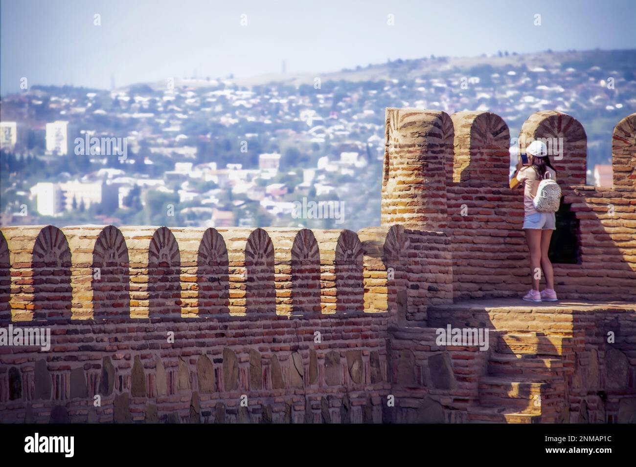 Ein Mädchen, das ein Foto von den Festungsmauern über Tiflis Georgia macht Stockfoto