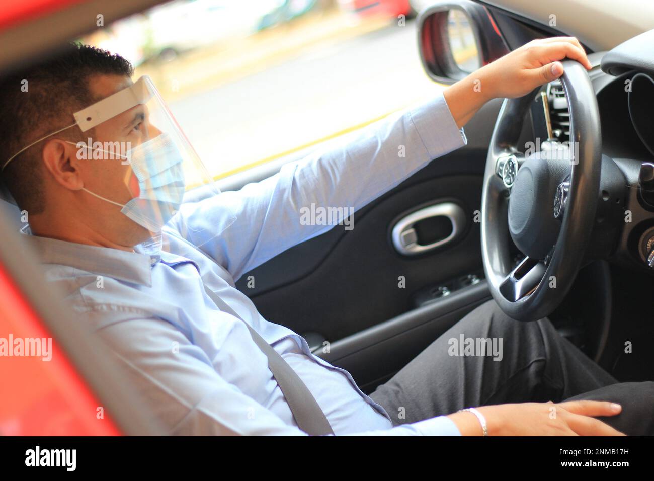 Latino-man-Fahrer mit Covid-19-Schutzmaske im Auto Stockfotografie - Alamy