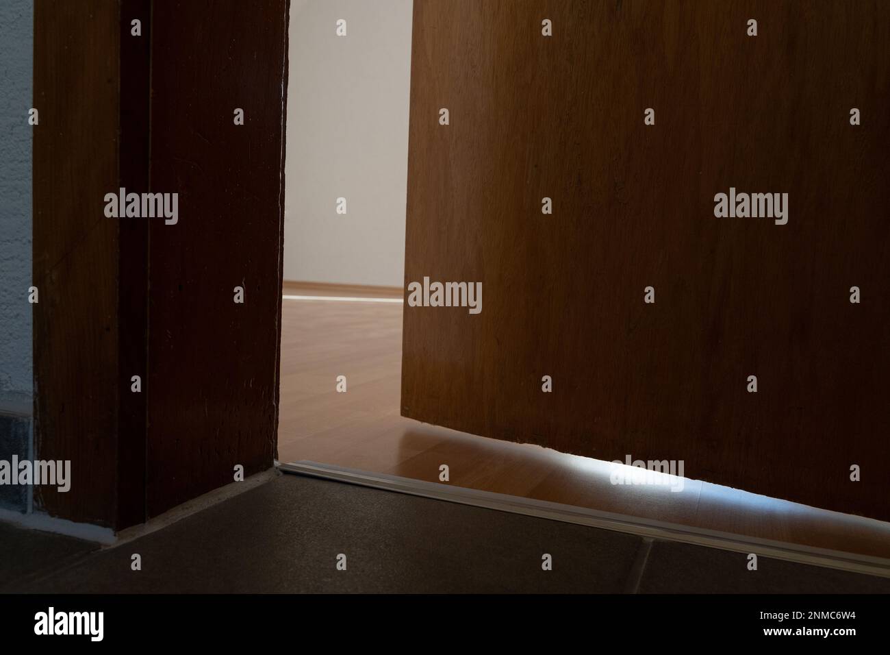 Alte, offene Holztür im Zimmer einer leeren Wohnung Stockfoto