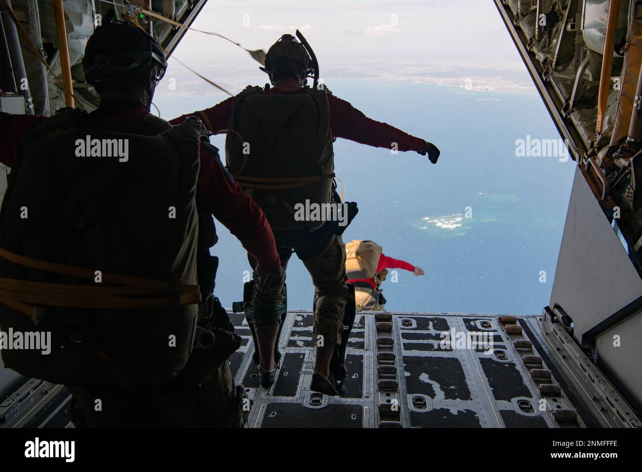 USA Pararescuemen der Luftwaffe, die dem 31. Rettungsgeschwader zugeteilt sind, springen aus einem 1. Sondereinsatzgeschwader MC-130J Kommando II, gefolgt von einem manipulierten Alternativboot oder RAMB über dem Pazifik, am 22. Februar 2023. Ziel war es, den RAMB zu erreichen, ein abgesenktes Raiding-Kampfschiff, das mit einem Fallschirm ins Wasser fallen und bei der Landung aufgeblasen werden kann. Der RAMB ermöglicht eine fortschrittlichere medizinische Behandlung für einen Patienten während einer Rettungsoperation im Ozean. (USA Air Force Foto von Airman 1. Class Tylir Meyer) Stockfoto