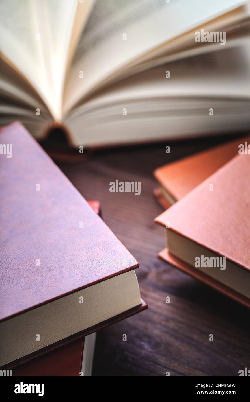 Eine Reihe Bücher auf einem Holztisch mit einem offenen Tisch. Stockfoto