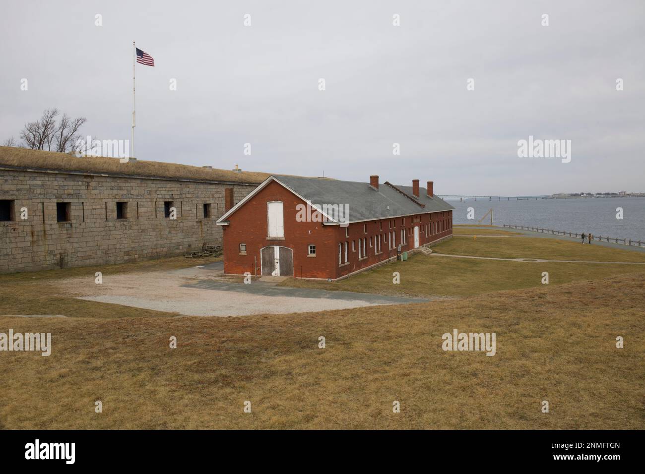 Rotes Backsteingebäude im Fort Adams State Park in Newport, Rhode Island. Ehemaliger Posten der US-Armee in RI. Blick auf Brücke und Wasser im Hintergrund. Stockfoto